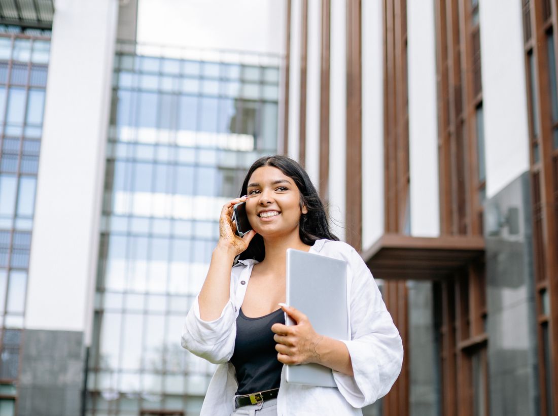 Indian exporter smiling on a call between client meetings