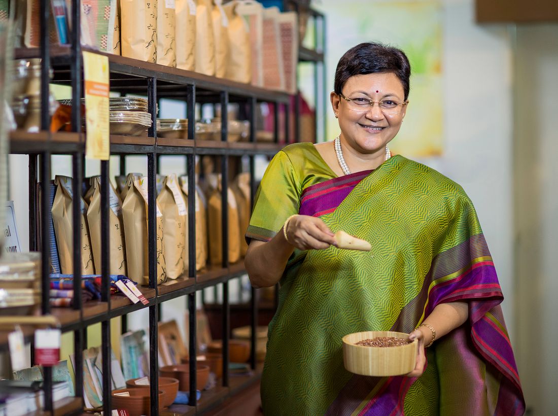 Indian exporter smiling at her shop full of products ready to ship